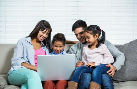 family looking at laptop