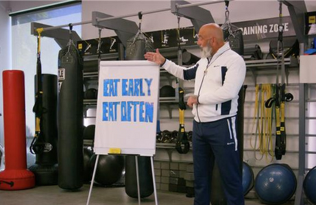 Eat Early Eat Often coach pointing to whiteboard 