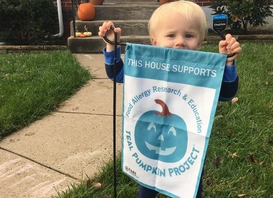 Kid with Teal Pumpkin sign