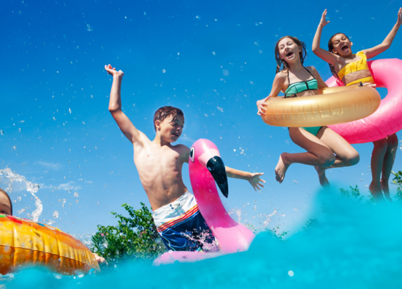 Kids splashing in a pool wearing floaties