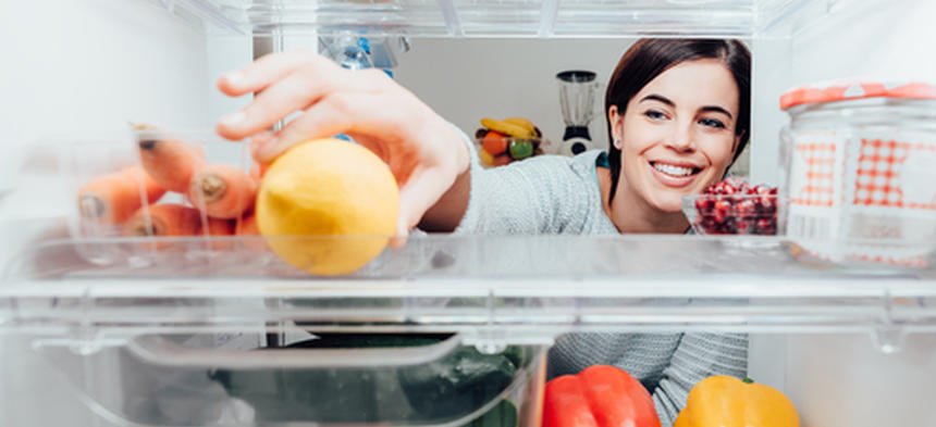 girl reaching in fridge