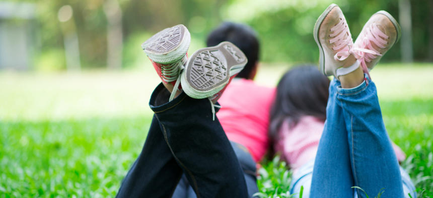 Teens laying in grass